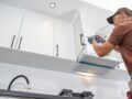 Man installing kitchen cabinets during a home renovation project in Charlotte