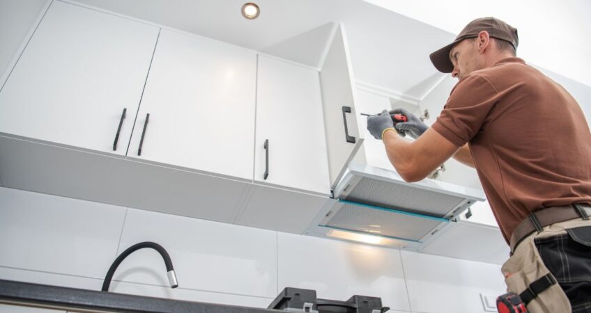 Man installing kitchen cabinets during a home renovation project in Charlotte